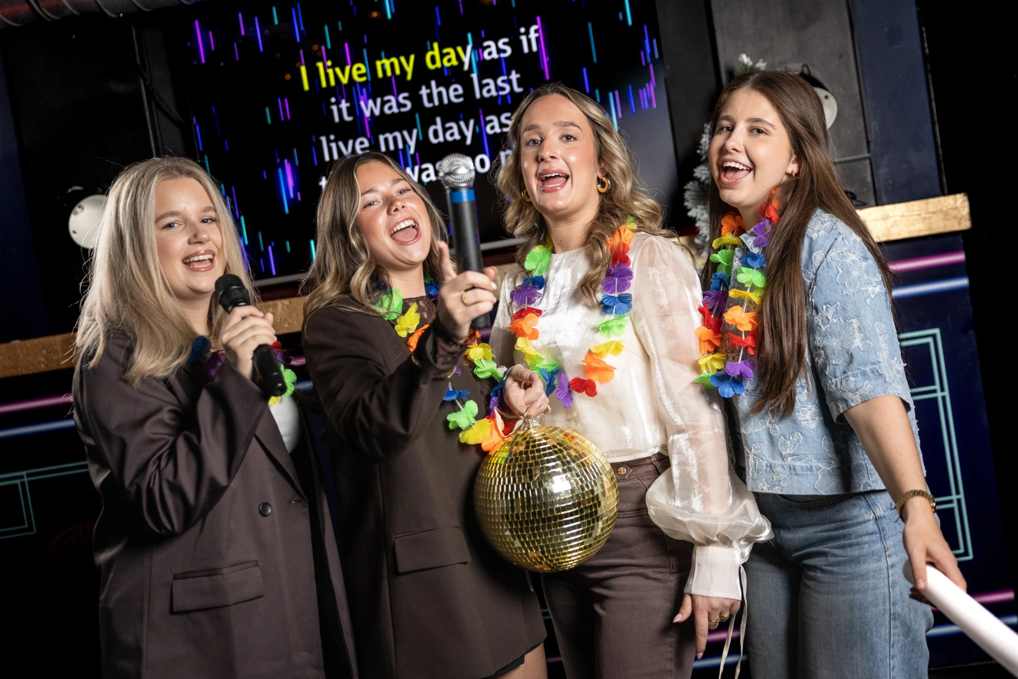 Vriendinnen zingen karaoke met microfoons bij Sing! Café