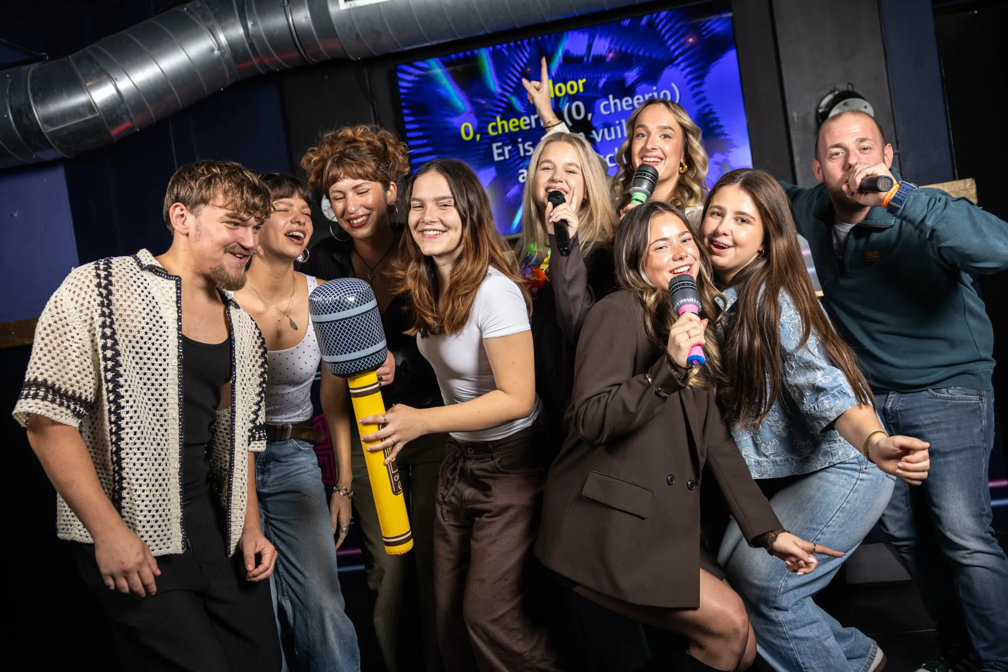 Een groep vrienden zingt samen karaoke bij Sing! Café