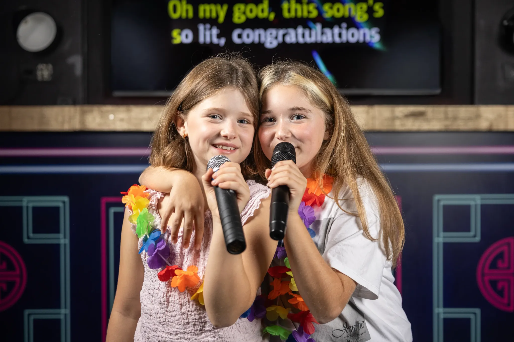 Twee mensen zingen een karaoke-duet bij Sing! Café