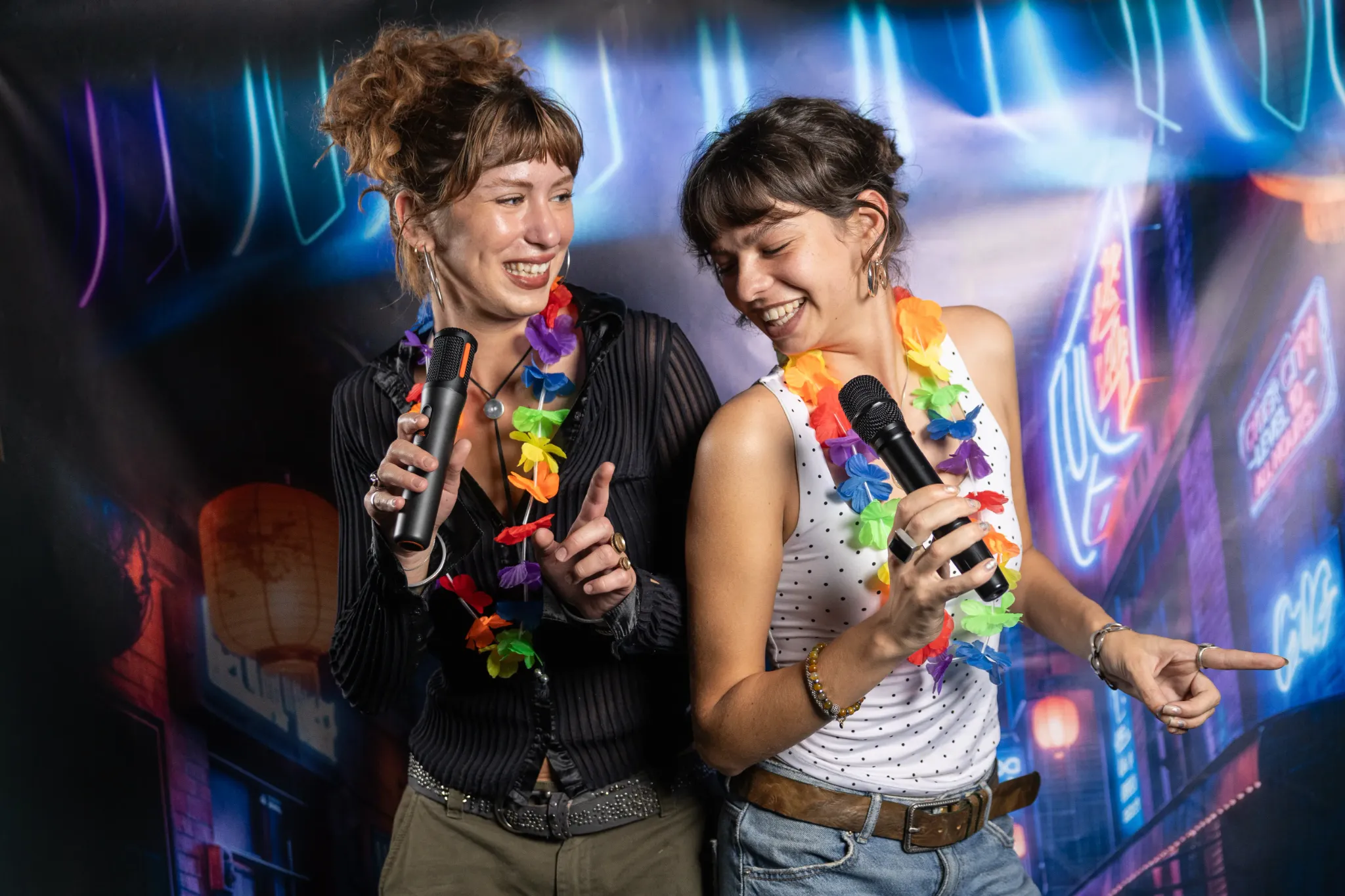 Twee vriendinnen zingen karaoke met microfoons